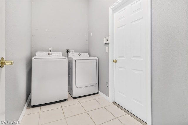 laundry room with electric dryer hookup, washing machine and dryer, and light tile floors