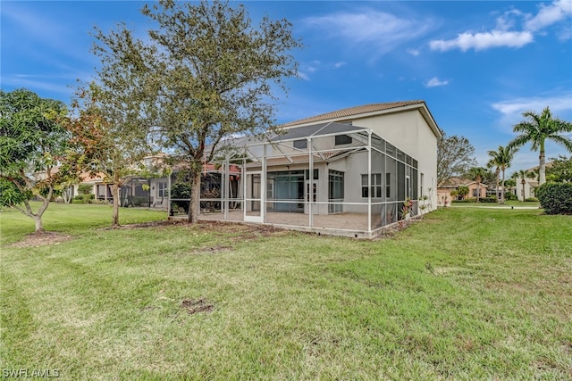 back of property with a yard and glass enclosure