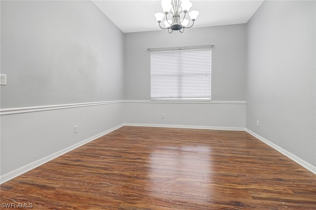 unfurnished room with dark hardwood / wood-style floors and a notable chandelier