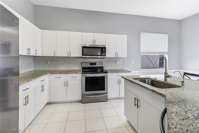 kitchen featuring white cabinets, sink, appliances with stainless steel finishes, and light stone counters