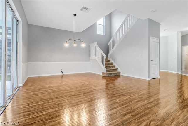 interior space with a towering ceiling and hardwood / wood-style floors