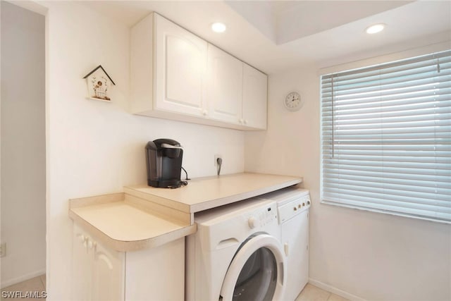 laundry area featuring electric dryer hookup, independent washer and dryer, light tile floors, and cabinets