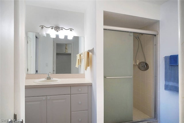 bathroom with a shower with shower door and vanity