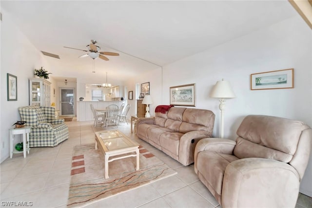 living room with ceiling fan with notable chandelier and light tile floors