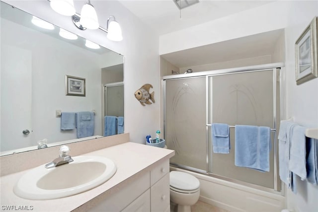 full bathroom featuring vanity, shower / bath combination with glass door, and toilet