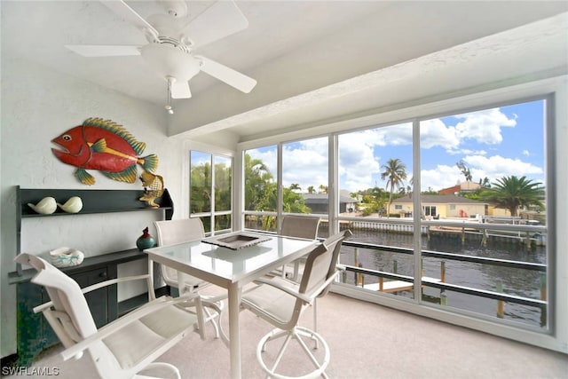 carpeted home office with a water view and ceiling fan