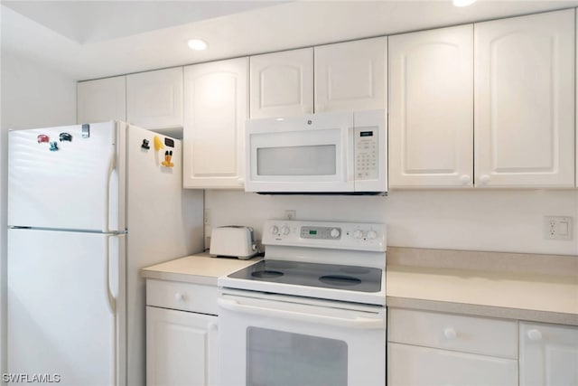 kitchen with white appliances and white cabinetry