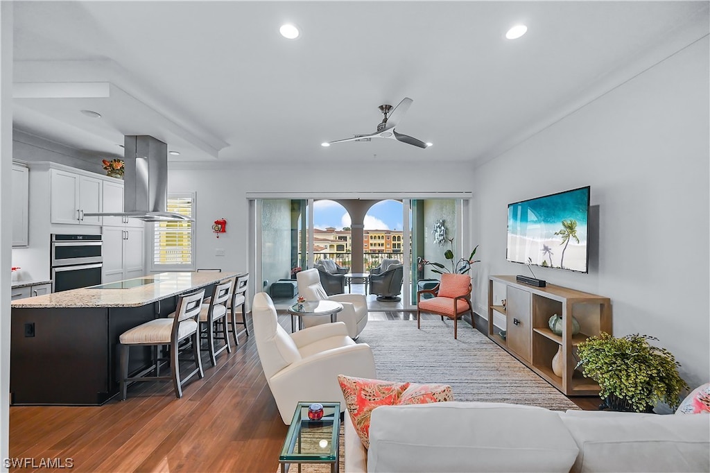 living room with ceiling fan and dark hardwood / wood-style floors