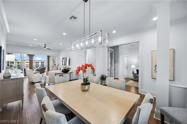 dining room with dark hardwood / wood-style floors and ceiling fan with notable chandelier