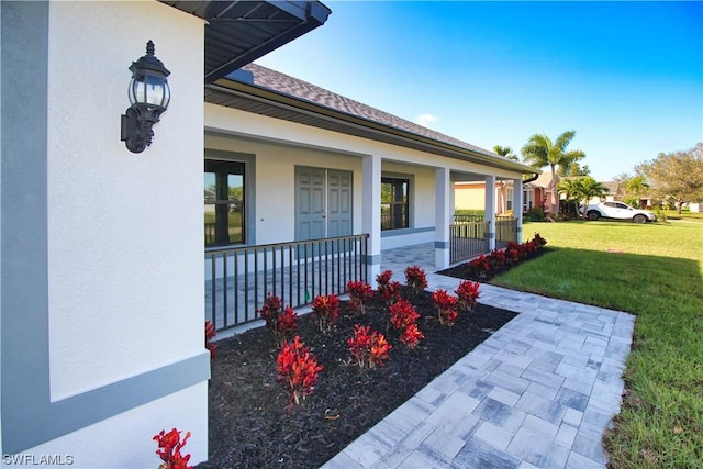 property entrance featuring a yard and covered porch