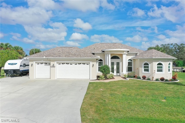 view of front of home with a garage, french doors, and a front lawn