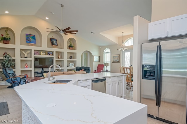 kitchen with pendant lighting, white cabinets, sink, light stone countertops, and appliances with stainless steel finishes