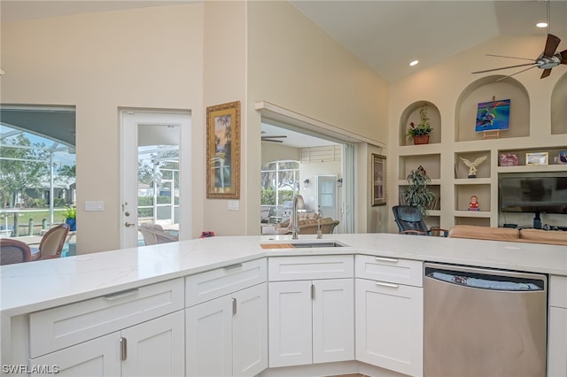 kitchen featuring stainless steel dishwasher, light stone countertops, white cabinetry, and sink