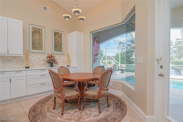 tiled dining area featuring plenty of natural light and vaulted ceiling