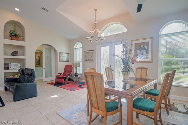 dining space featuring built in shelves, lofted ceiling, a notable chandelier, and light tile patterned flooring