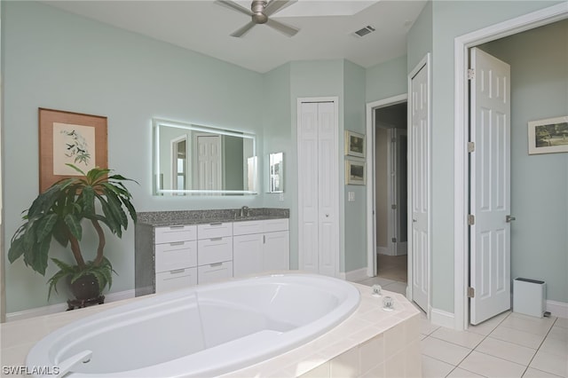 bathroom with vanity, a relaxing tiled tub, tile patterned floors, and ceiling fan