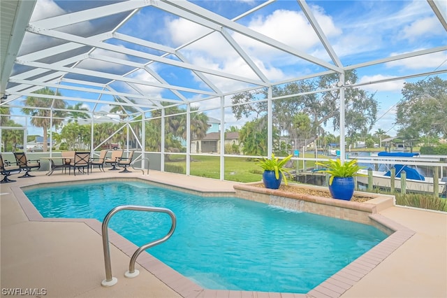 view of swimming pool with pool water feature, glass enclosure, and a patio area