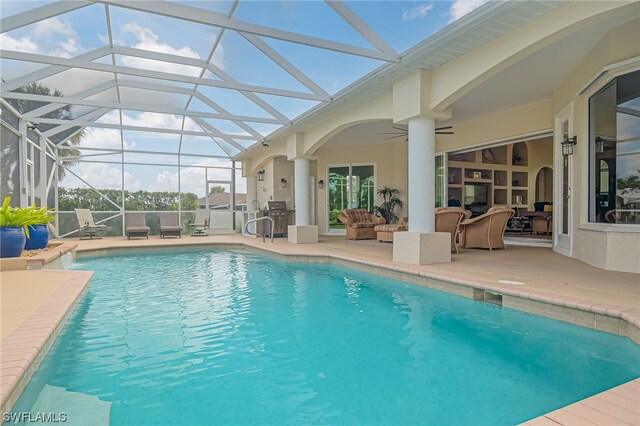 view of pool featuring a lanai, ceiling fan, a patio area, and an outdoor hangout area