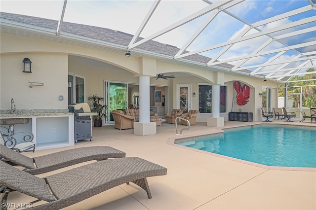 view of pool with a lanai, outdoor lounge area, a patio area, and ceiling fan