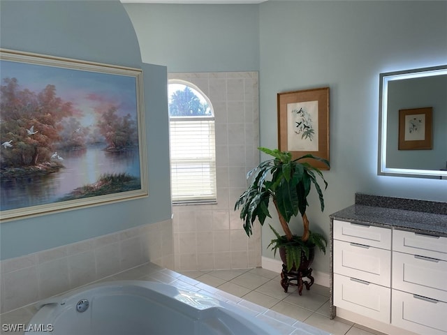 bathroom with tile patterned floors, a bathtub, and vanity