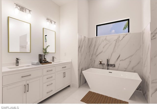 bathroom featuring tile walls, tile floors, dual vanity, and a washtub