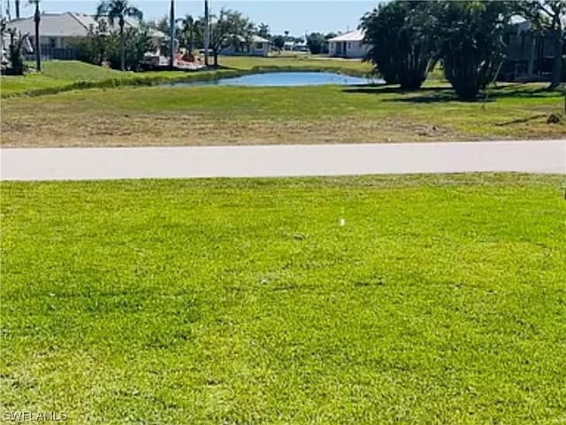 view of property's community with a water view and a lawn