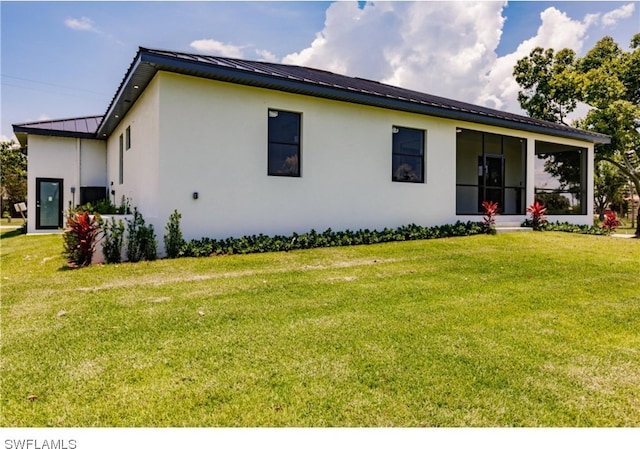 view of front facade with a front yard and a sunroom