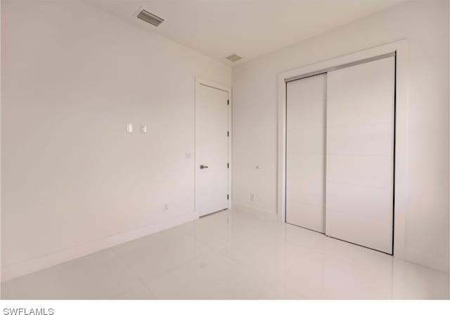 unfurnished bedroom featuring a closet and light tile flooring