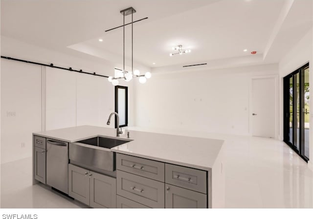 kitchen with a raised ceiling, hanging light fixtures, dishwasher, and light tile flooring