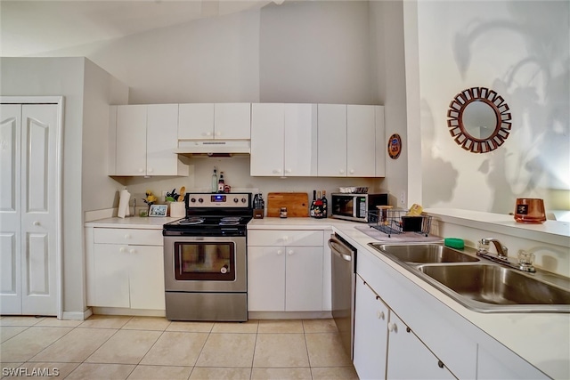 kitchen with sink, light tile floors, white cabinets, appliances with stainless steel finishes, and high vaulted ceiling