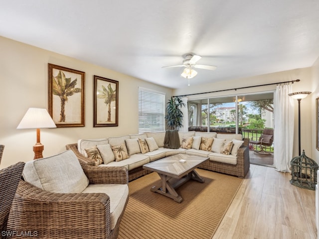 living room with light hardwood / wood-style flooring and ceiling fan