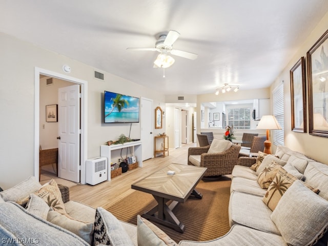 living room featuring light hardwood / wood-style floors and ceiling fan