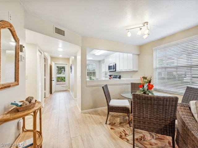 dining room featuring track lighting and light hardwood / wood-style flooring