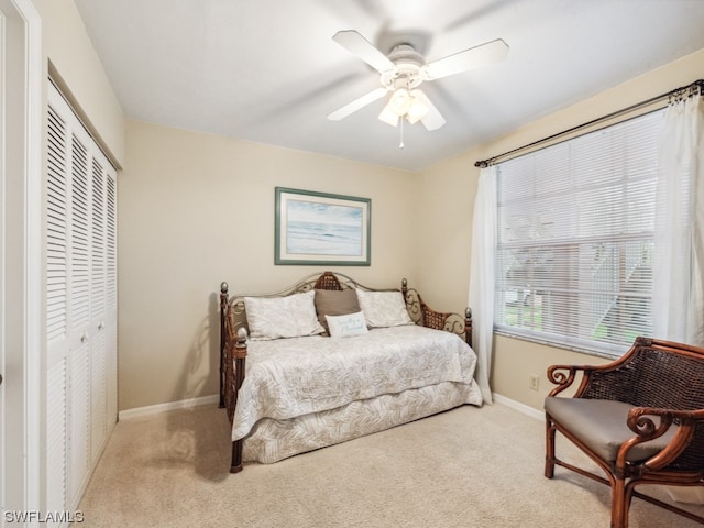 carpeted bedroom featuring a closet and ceiling fan