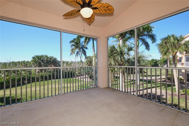 unfurnished sunroom with vaulted ceiling and ceiling fan