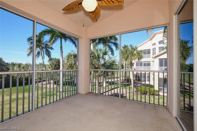 unfurnished sunroom featuring ceiling fan