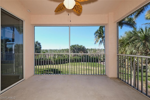 unfurnished sunroom with ceiling fan