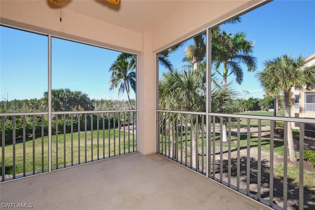 unfurnished sunroom with ceiling fan