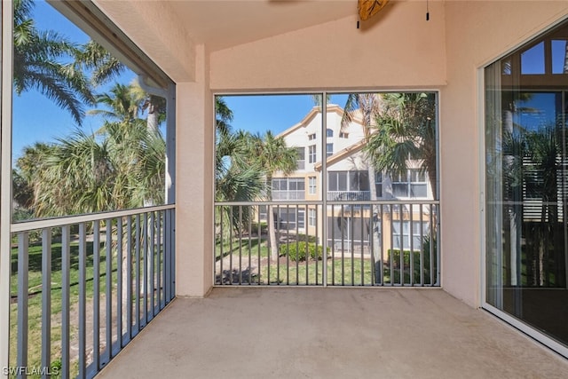 unfurnished sunroom with ceiling fan and vaulted ceiling