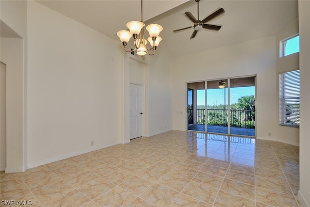 empty room featuring light tile floors, ceiling fan with notable chandelier, and a high ceiling