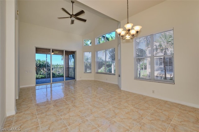 tiled spare room featuring plenty of natural light, ceiling fan with notable chandelier, and vaulted ceiling