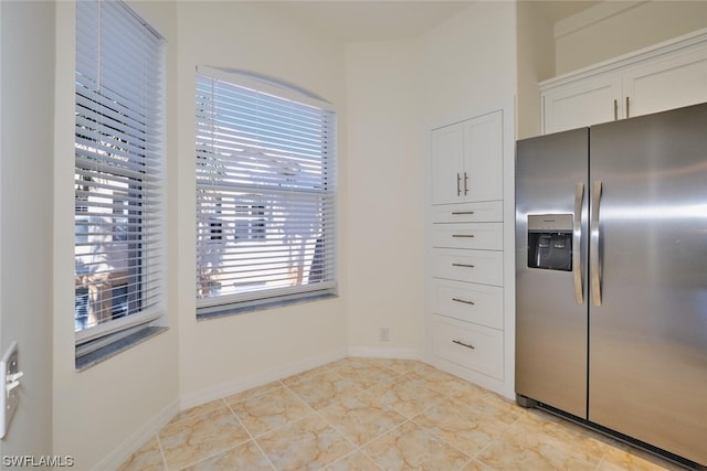 kitchen with white cabinets, stainless steel fridge with ice dispenser, and light tile flooring