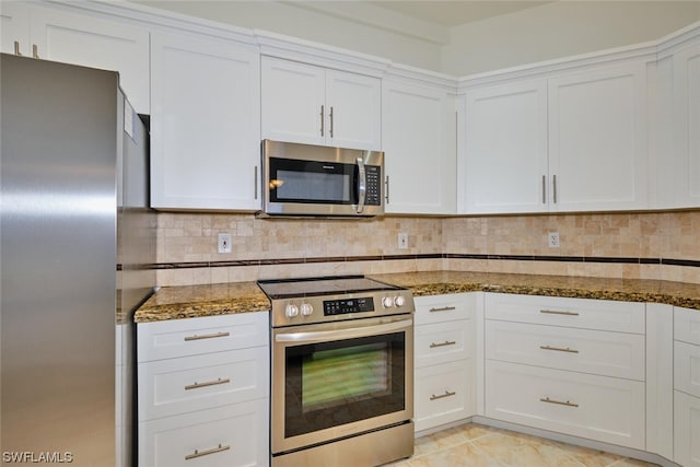 kitchen featuring appliances with stainless steel finishes, white cabinetry, and tasteful backsplash