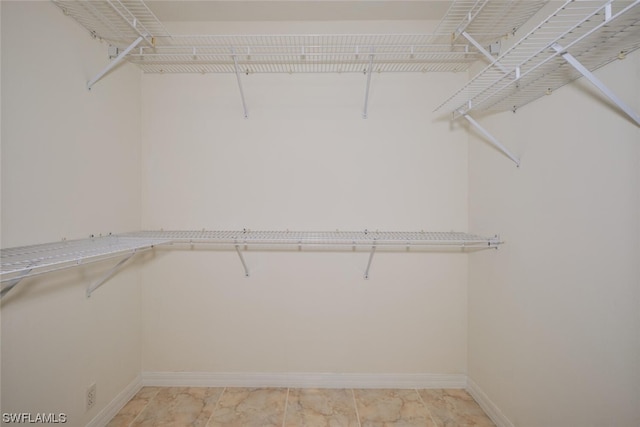 spacious closet featuring light tile flooring