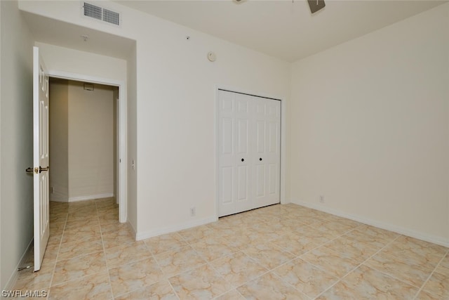 unfurnished bedroom featuring a closet and light tile floors