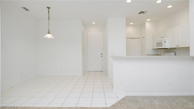 kitchen with hanging light fixtures, white cabinetry, and light tile patterned floors