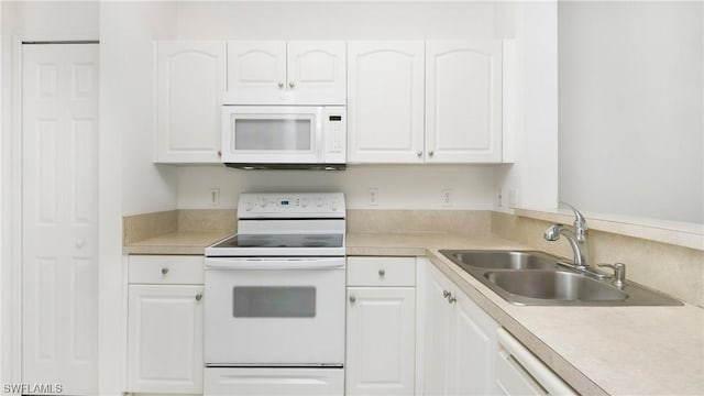 kitchen with white cabinetry, sink, and white appliances