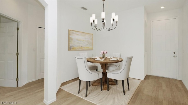 dining room with a notable chandelier and light wood-type flooring