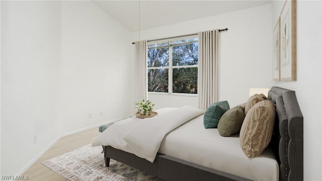 bedroom with light hardwood / wood-style floors and vaulted ceiling