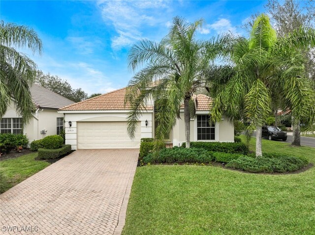 mediterranean / spanish-style home with a garage and a front lawn